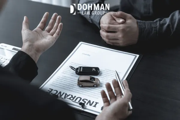Car insurance paperwork with toy car and keys.