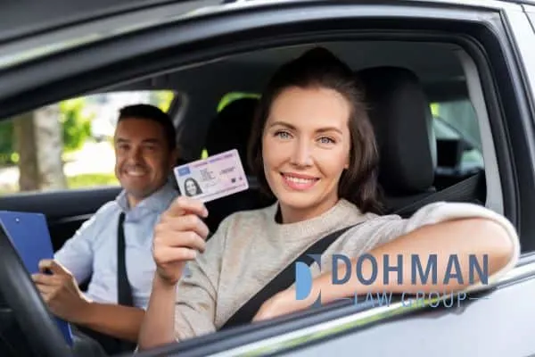 a woman holding up her new driver's license, How Long Do Points Stay on Your License