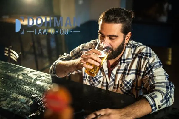 a man drinking a beer with his car keys in front of him at a bar