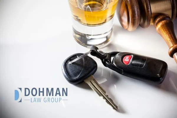 glass of liquor next to car keys and a gavel