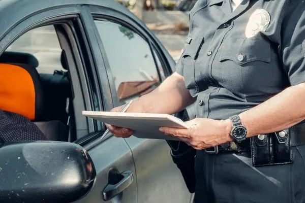 a police officer writing a driver a ticket