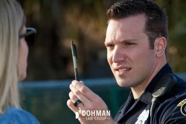 a police officer having a woman perform a field sobriety test
