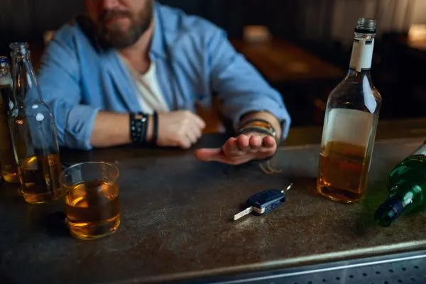 Man at the bar declining a drink with car key in front of him