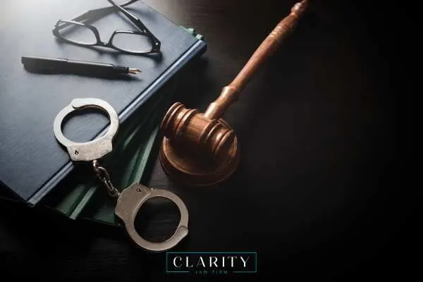 legal books, glasses, handcuffs, and a gavel on a desk