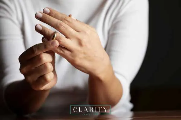 a womens hand taking her wedding ring on