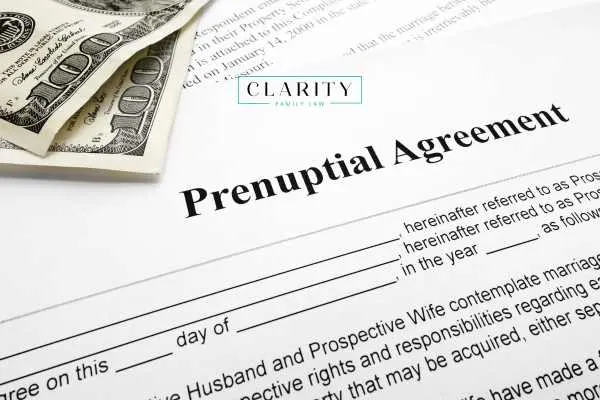 A close-up of a legal "Prenuptial Agreement" document with two $100 bills resting on the corner