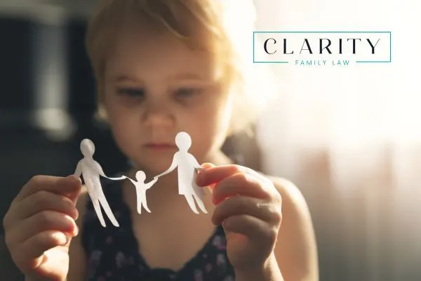 a child holding paper cut outs of a family