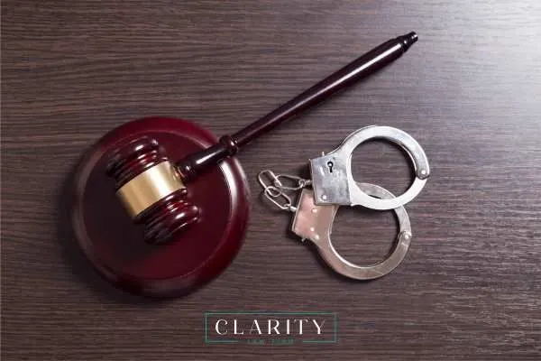 handcuffs and a gavel on a wooden desk