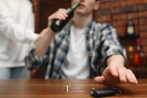 a man at a bar reaching for his car keys