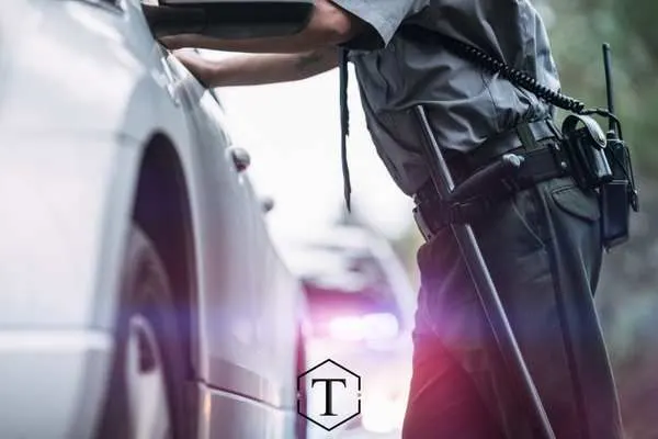 a police officer talking to a driver after pulling them over