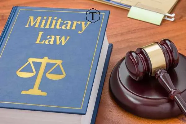 a book on military law and gavel on a desk