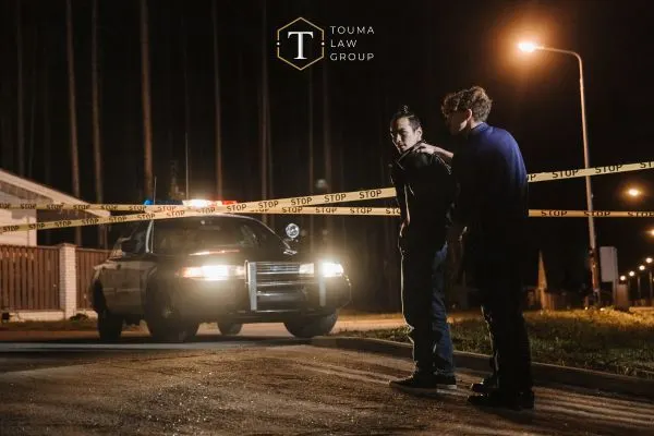 a young man being arrested at night