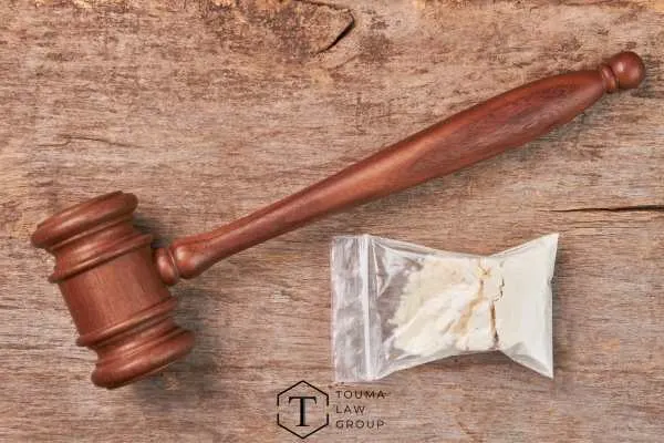 a gavel and bag of drugs on a wooden table