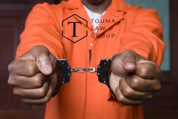a person in an orange jumpsuit with their hands in handcuffs