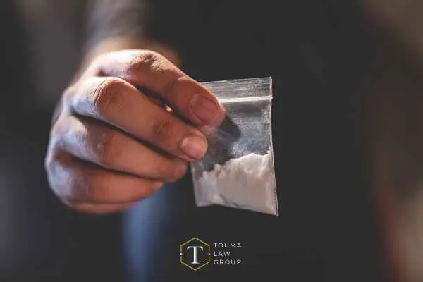 a man holding a baggie with heroin in it
