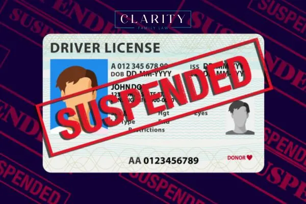An illustration of a driver's license with a prominent red "SUSPENDED" stamp across it, set against a dark background with a repeating, faded "SUSPENDED" pattern. The "Clarity Family Law" logo is at the top.
