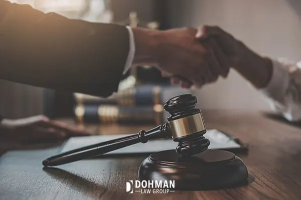 attorney shaking hands across a gavel