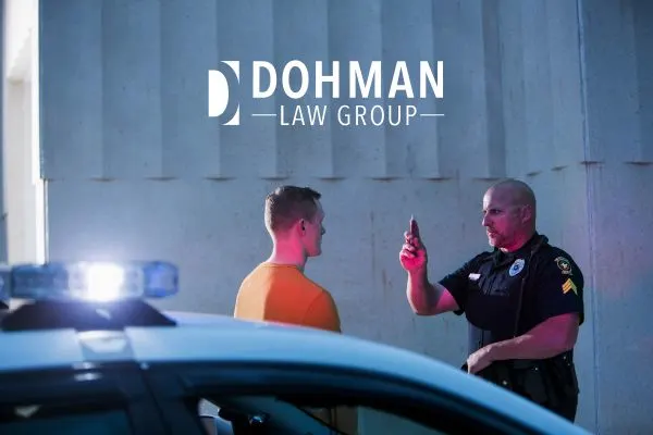 Police officer administering a field sobriety test to a man.