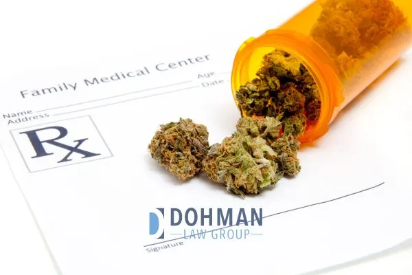 Marijuana buds spill from an orange prescription bottle onto a medical prescription form.