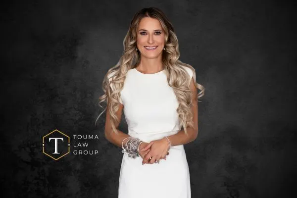 female attorney in white dress with Touma logo