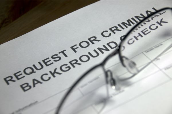 form for request for criminal background check with glasses laid on top