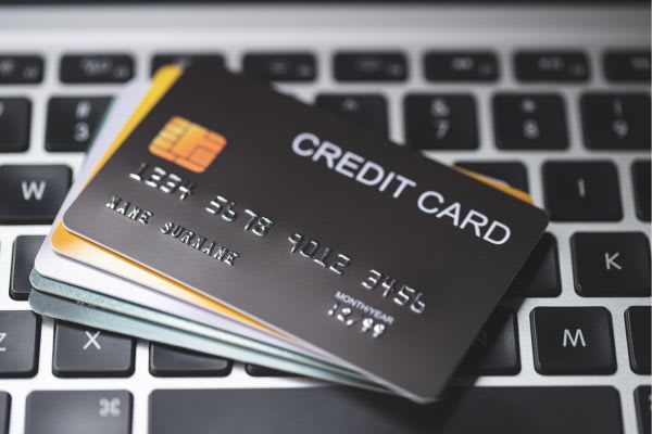 stack of credit cards sitting on computer keyboard