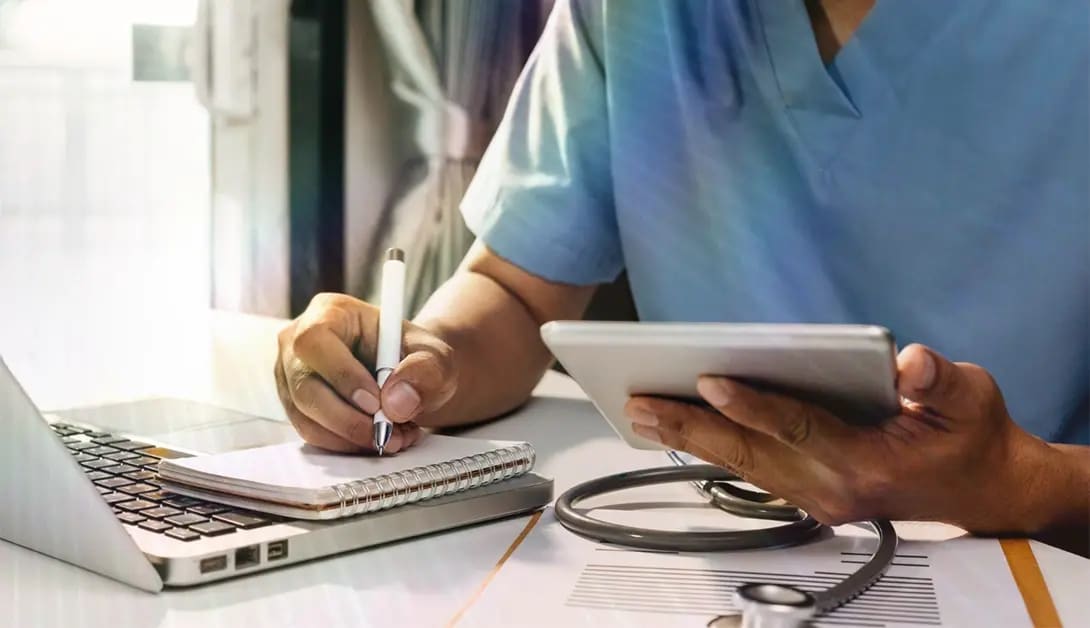 neet-pg-2026-preparation Doctor preparing for NEET PG 2026 using a laptop, tablet and study notes