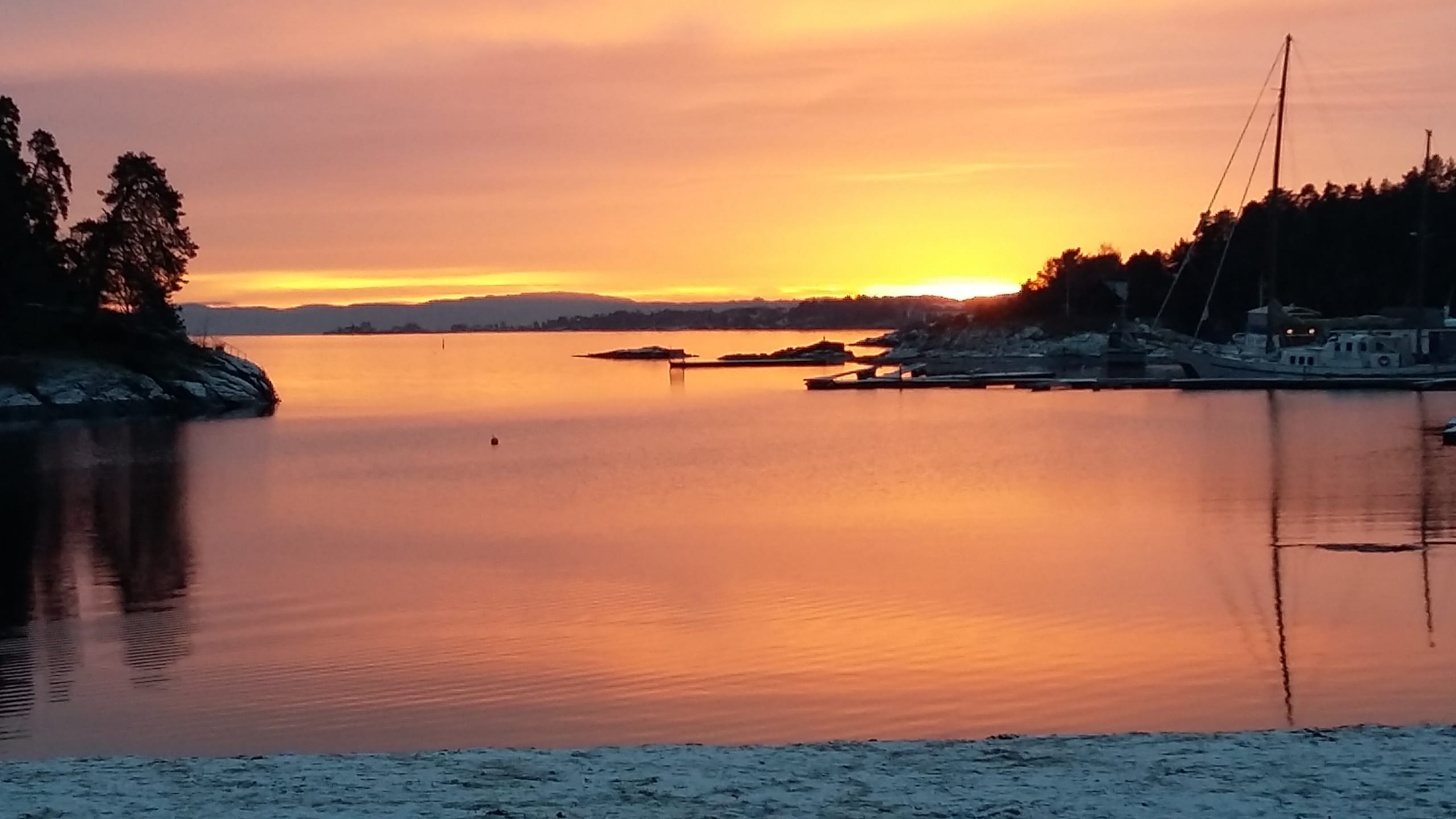 A coastal view featuring a bright red sunset in Oslo.