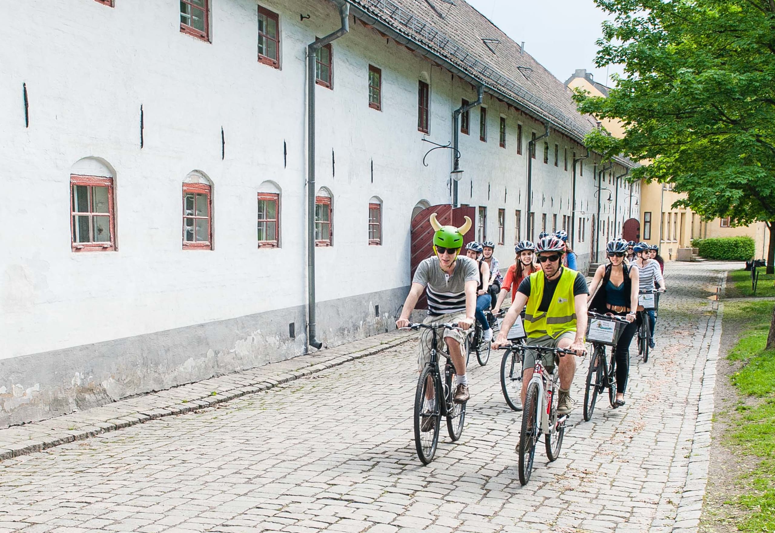 A group of tourists exploring historical sites in Oslo by bike.