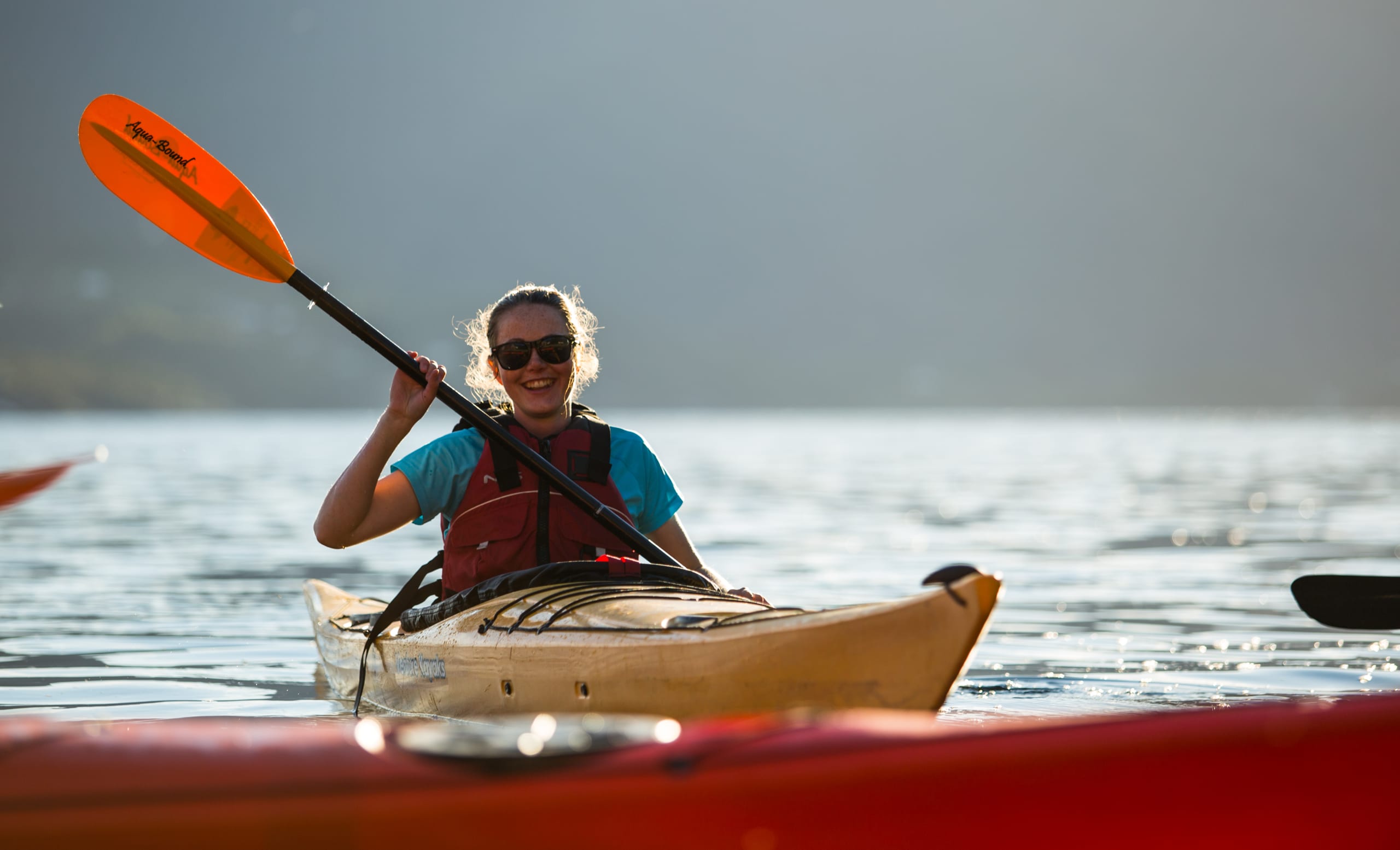 Smiling girl kayaking on the Hardangerfjord