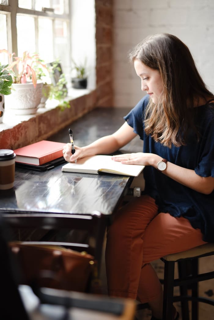 A freelancer working on a laptop at a wooden desk
