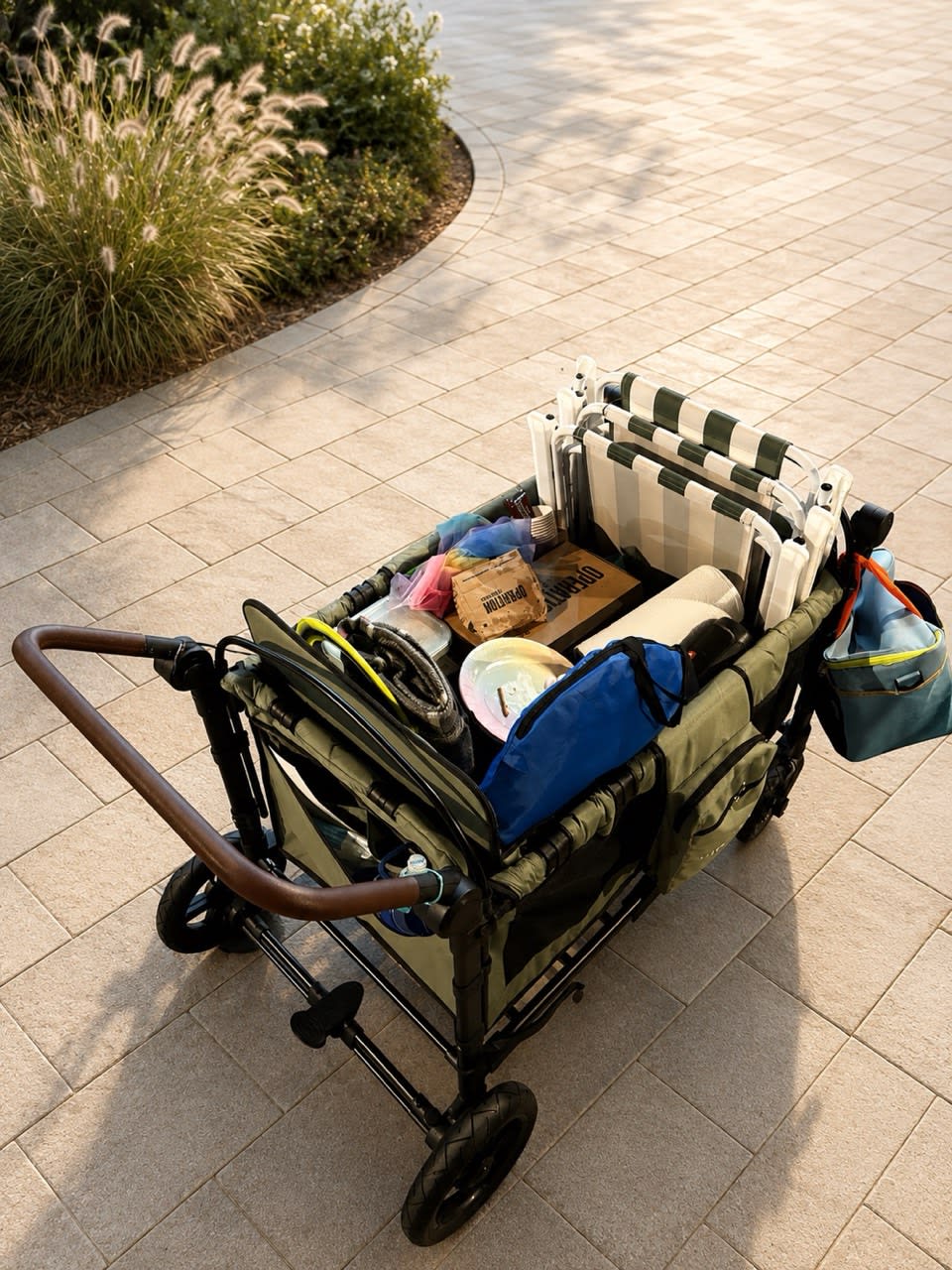 STROLLZ. stroller wagon carrying beach chairs, picnic supplies and family essentials, demonstrating its large storage capacity for everyday adventures.