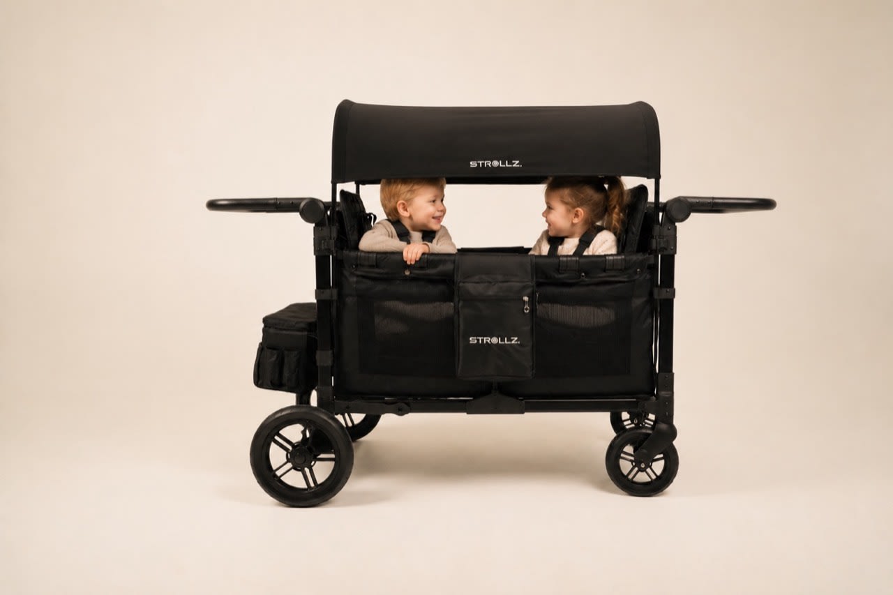Two children enjoying a ride together in a STROLLZ. stroller wagon.