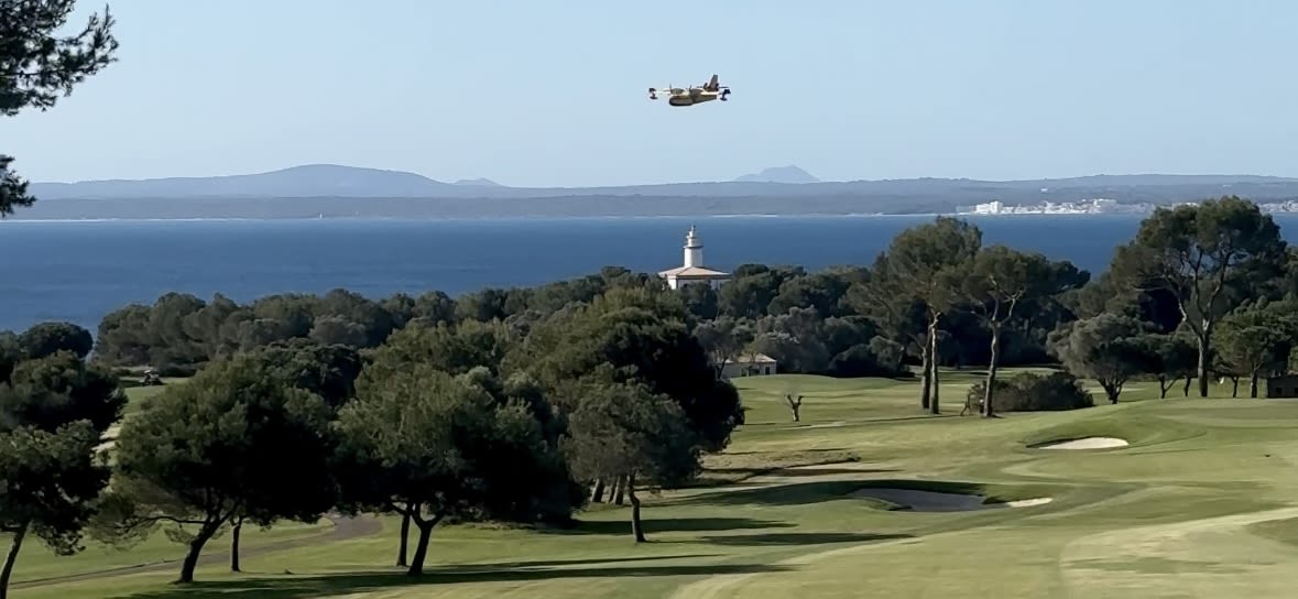 Der Leuchtturm von Alcanada und ein Wasserflugzeug im Landeanflug