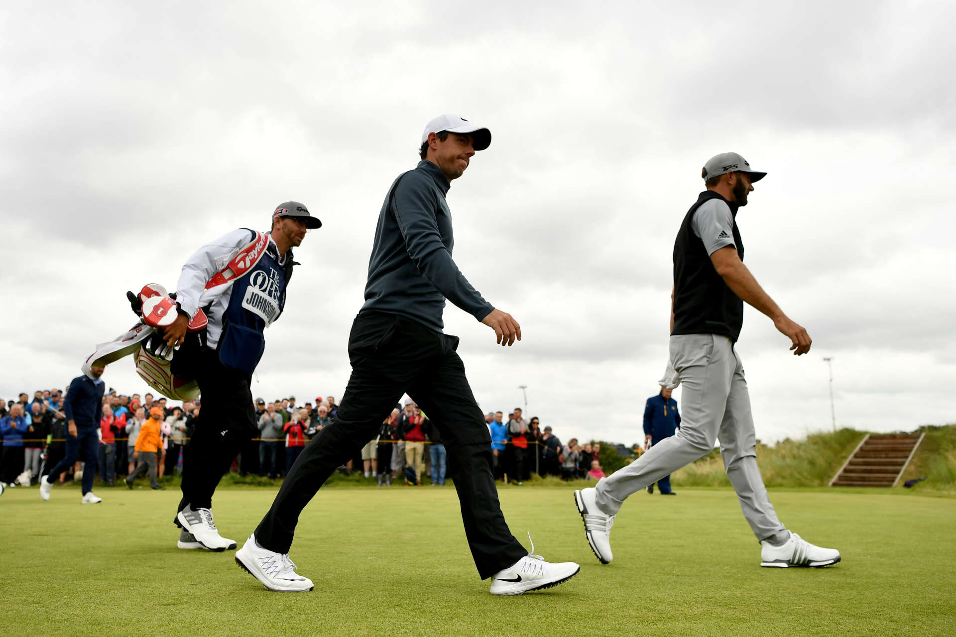 Dustin Johnson und Rory McIlroy laufen bei der 146th Open Championship 2017 im Royal Birkdale Golf Club zu ihren Bällen.