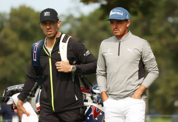 MAMARONECK, NEW YORK - SEPTEMBER 15: Rickie Fowler (R) of the United States walks with caddie Joe Skovron (L) during a practice round prior to the 120th U.S. Open Championship on September 15, 2020 at Winged Foot Golf Club in Mamaroneck, New York. (Photo by Gregory Shamus/Getty Images)