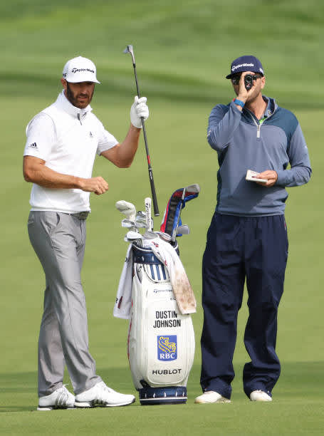 MAMARONECK, NEW YORK - SEPTEMBER 15: Dustin Johnson of the United States prepares to play an approach shot alongside caddie Austin Johnson during a practice round prior to the 120th U.S. Open Championship on September 15, 2020 at Winged Foot Golf Club in Mamaroneck, New York. (Photo by Jamie Squire/Getty Images)