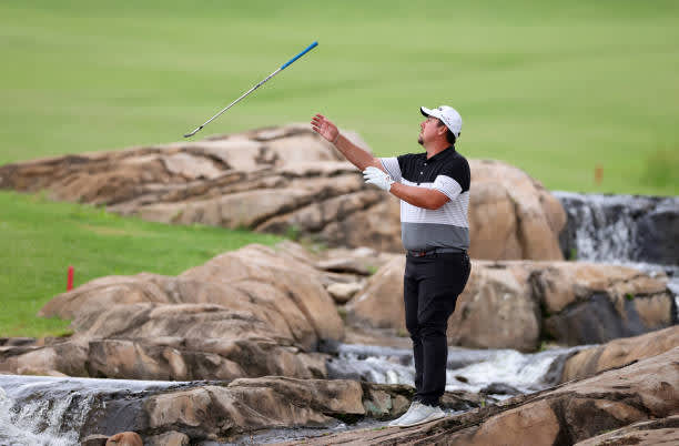 MALELANE, SOUTH AFRICA - NOVEMBER 27: AHLERS, Jaco Ahlers of South Africa catches his club passed to him by his caddie over the river between the 9th and 18th holes during the second round of the Alfred Dunhill Championship at Leopard Creek Country Golf Club on November 27, 2020 in Malelane, South Africa. (Photo by Richard Heathcote/Getty Images)
