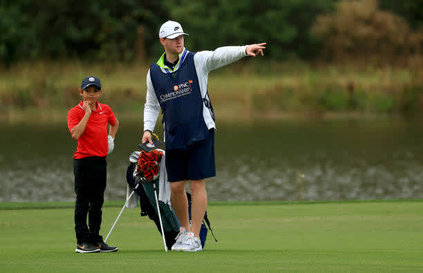 ORLANDO, FLORIDA - DECEMBER 20: Tiger Woods of the United States' son Charlie Woods line up a putt with caddie Joe LaCava Jr. on the 15th hole during the final round of the PNC Championship at the Ritz Carlton Golf Club on December 20, 2020 in Orlando, Florida. (Photo by Mike Ehrmann/Getty Images)