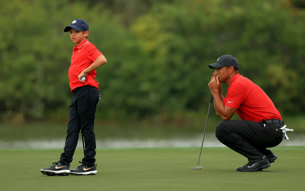ORLANDO, FLORIDA - DECEMBER 20: Tiger Woods of the United States and son Charlie Woods line up a putt on the 15th hole during the final round of the PNC Championship at the Ritz Carlton Golf Club on December 20, 2020 in Orlando, Florida. (Photo by Mike Ehrmann/Getty Images)