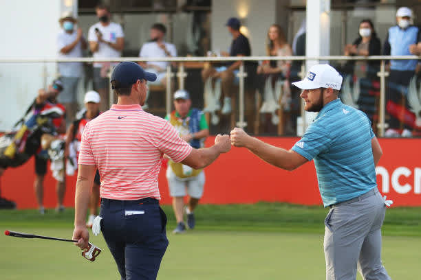 ABU DHABI, UNITED ARAB EMIRATES - JANUARY 23: Rory McIlroy of Northern Ireland and Tyrrell Hatton of England fist bump on the 18th green during Day Three of the Abu Dhabi HSBC Championship at Abu Dhabi Golf Club on January 23, 2021 in Abu Dhabi, United Arab Emirates. (Photo by Warren Little/Getty Images)