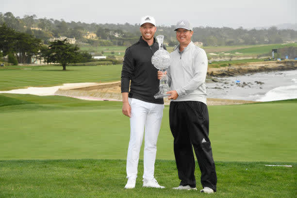 PEBBLE BEACH, CALIFORNIA - FEBRUARY 14: Daniel Berger of the United States celebrates with the trophy and his caddie Josh Cassell after winning during the final round of the AT&T Pebble Beach Pro-Am at Pebble Beach Golf Links on February 14, 2021 in Pebble Beach, California. (Photo by Harry How/Getty Images)
