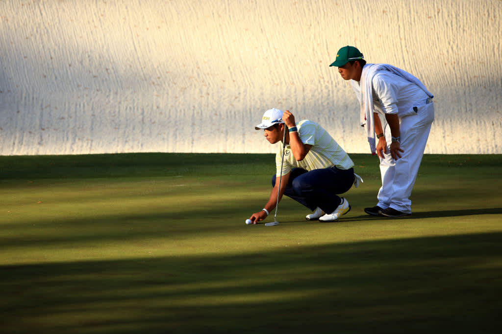 AUGUSTA, GEORGIA - APRIL 11: Hideki Matsuyama of Japan and to his caddie, Shota Hayafuji, look over a putt on the 16th green during the final round of the Masters at Augusta National Golf Club on April 11, 2021 in Augusta, Georgia. (Photo by Mike Ehrmann/Getty Images)