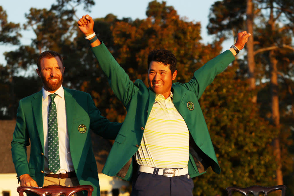 AUGUSTA, GEORGIA - APRIL 11: Hideki Matsuyama of Japan celebrates as 2020 Masters champion Dustin Johnson of the United States places the green jacket on him after winning the Masters at Augusta National Golf Club on April 11, 2021 in Augusta, Georgia. (Photo by Kevin C. Cox/Getty Images)