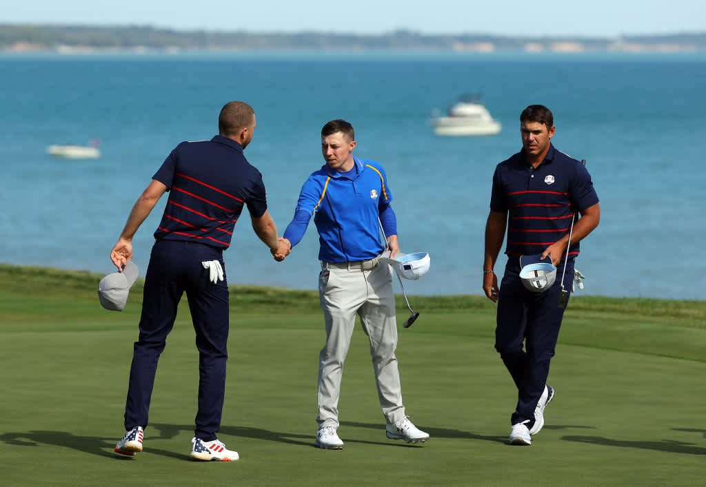 KOHLER, WISCONSIN - SEPTEMBER 24: Daniel Berger of team United States and Matthew Fitzpatrick of England and team Europe shake hands on the 17th green as Brooks Koepka looks on during Friday Morning Foursome Matches of the 43rd Ryder Cup at Whistling Straits on September 24, 2021 in Kohler, Wisconsin. (Photo by Andrew Redington/Getty Images)