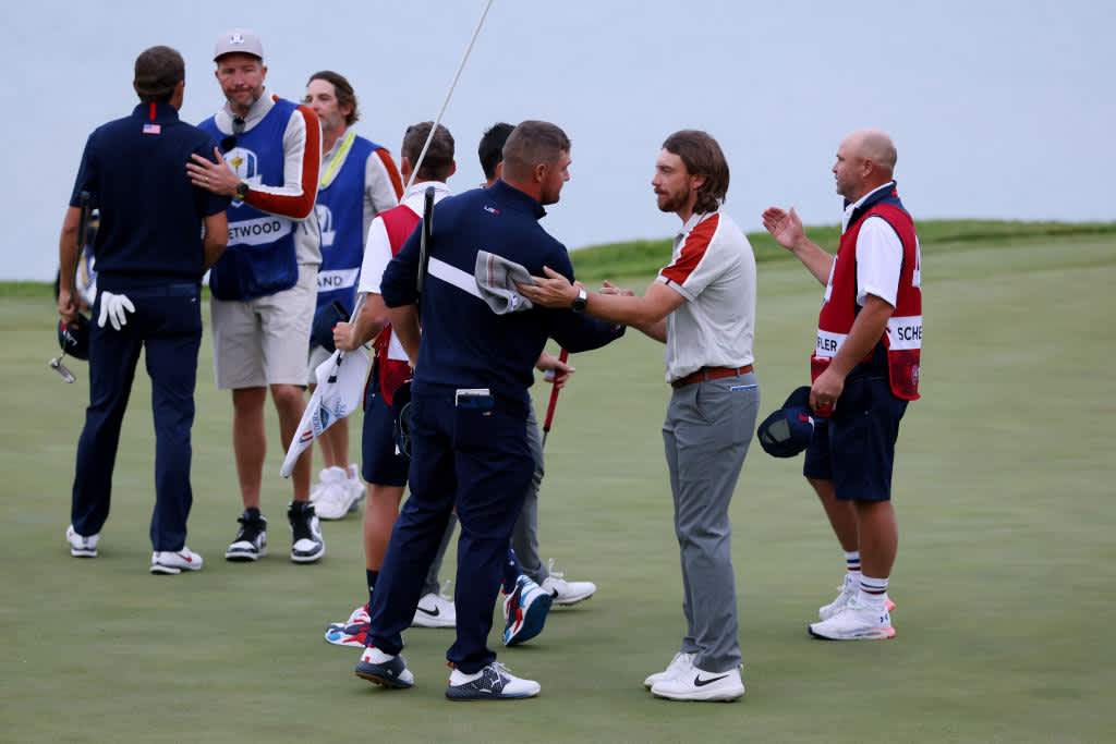 KOHLER, WISCONSIN - SEPTEMBER 25: Scottie Scheffler of team United States and Bryson DeChambeau of team United States shake hands with Tommy Fleetwood of England and team Europe and Viktor Hovland of Norway and team Europe after defeating them 3&1 during Saturday Morning Foursome Matches of the 43rd Ryder Cup at Whistling Straits on September 25, 2021 in Kohler, Wisconsin. (Photo by Richard Heathcote/Getty Images)