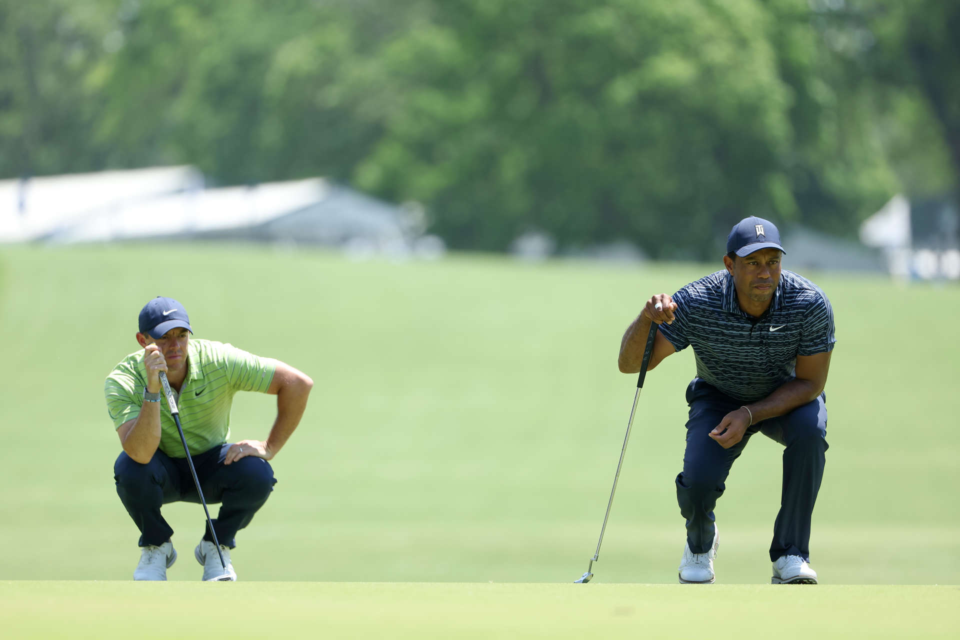 TULSA, OKLAHOMA - MAY 19: Tiger Woods of the United States and Rory McIlroy of Northern Ireland line up putt on the sixth green during the first round of the 2022 PGA Championship at Southern Hills Country Club on May 19, 2022 in Tulsa, Oklahoma. (Photo by Christian Petersen/Getty Images)