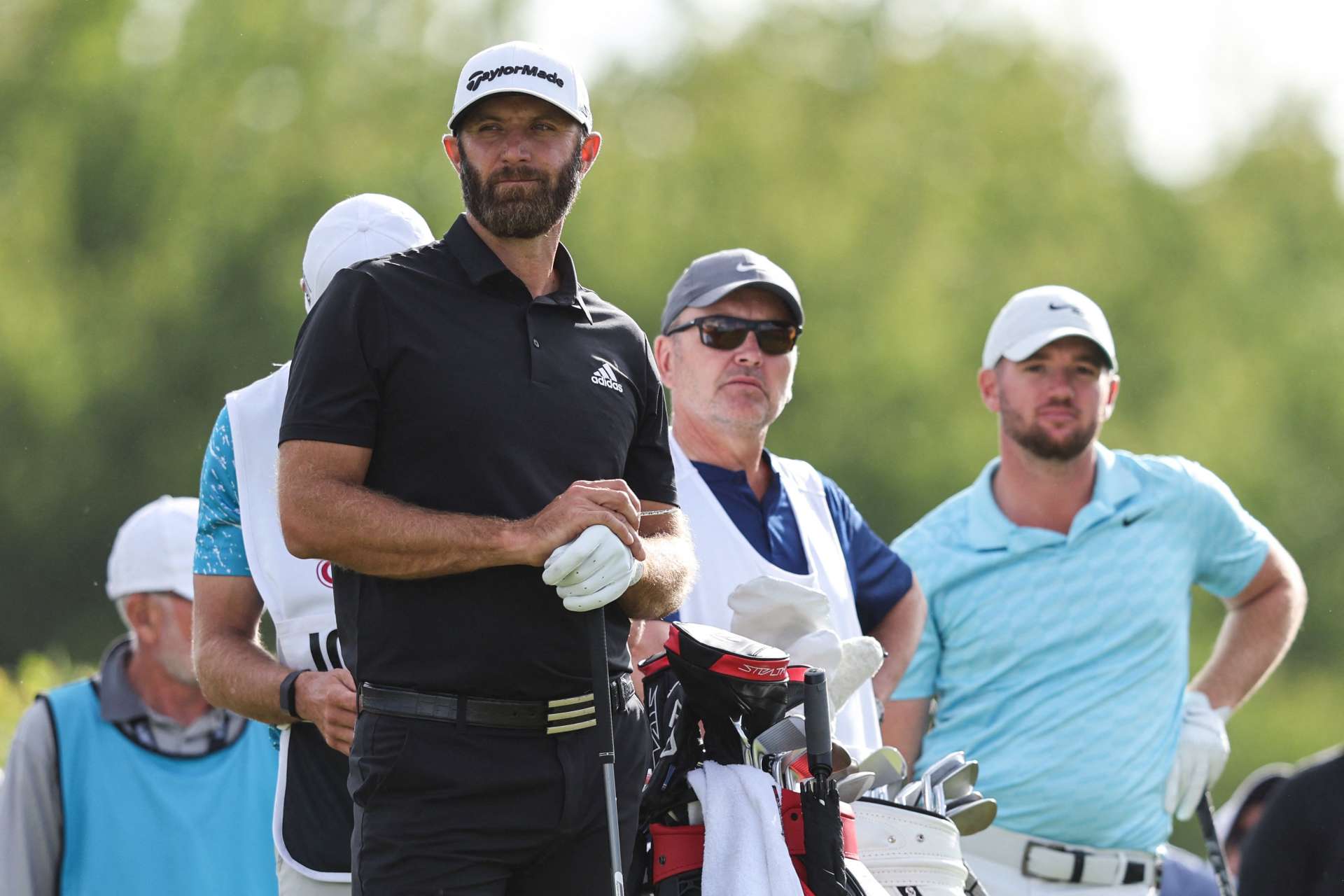 US golfer Dustin Johnsonnson (front C) and English golfer Sam Horsfield (rear R) react as they play on the third and final day of the LIV Golf Invitational Series event at The Centurion Club in St Albans, north of London, on June 11, 2022. - The LIV Golf Invitational London, the launch event of a lucrative and divisive series that is rocking the sport reaches it's conclusion. The $25 million event in St Albans -- the biggest prize pot in history -- is the first of eight tournaments this year bankrolled by Saudi Arabia's sovereign wealth fund, worth a combined $255 million. (Photo by Adrian DENNIS / AFP) (Photo by ADRIAN DENNIS/AFP via Getty Images)