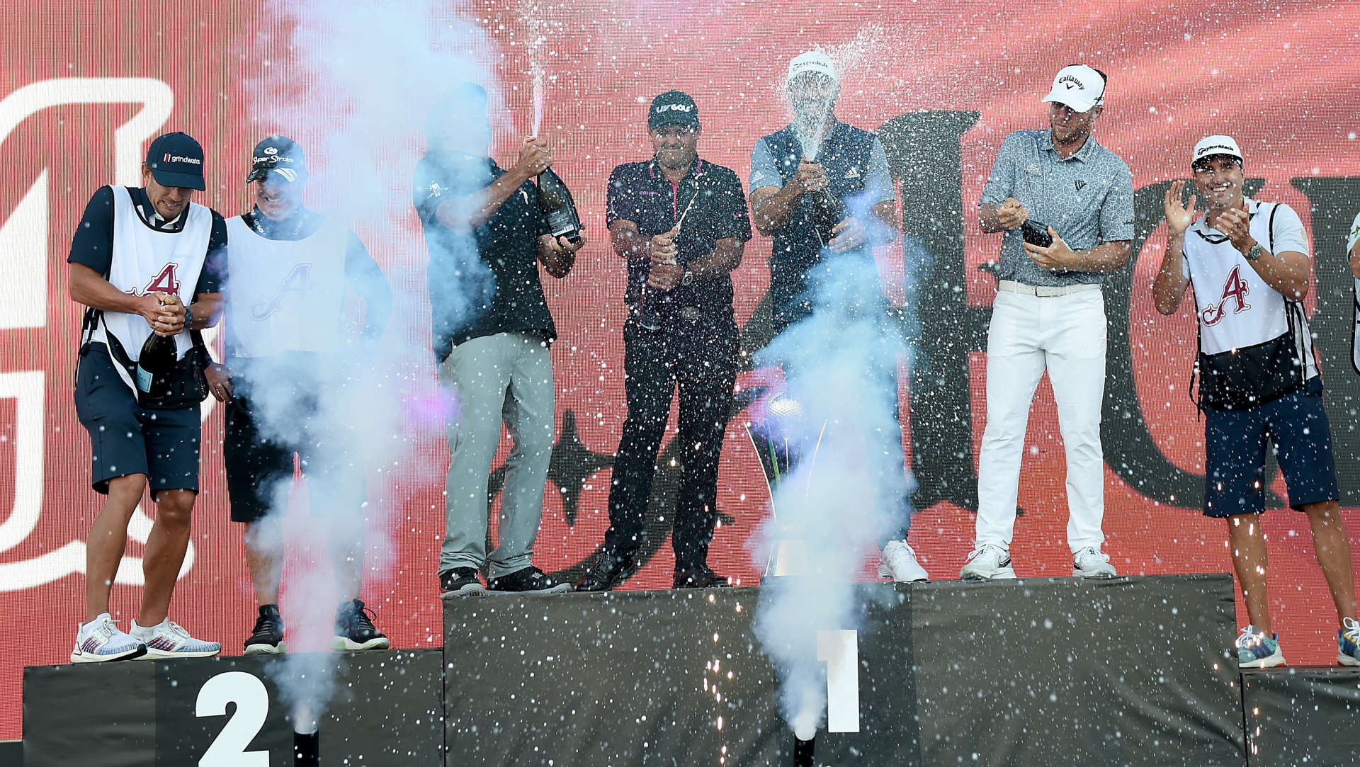 Members of the 4 Aces GC and their caddies celebrate their team win