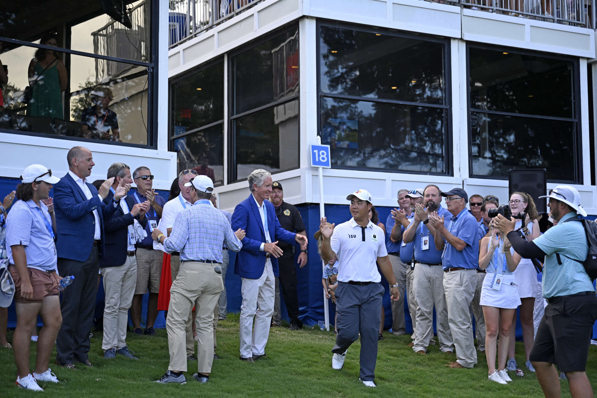 GREENSBORO, NORTH CAROLINA - AUGUST 07: Joohyung Kim of Korea walks back onto the 18th green to receive the trophy after putting in to win during the final round of the Wyndham Championship at Sedgefield Country Club on August 07, 2022 in Greensboro, North Carolina. (Photo by Eakin Howard/Getty Images)